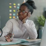 woman at desk looking suspiciously at co-worker